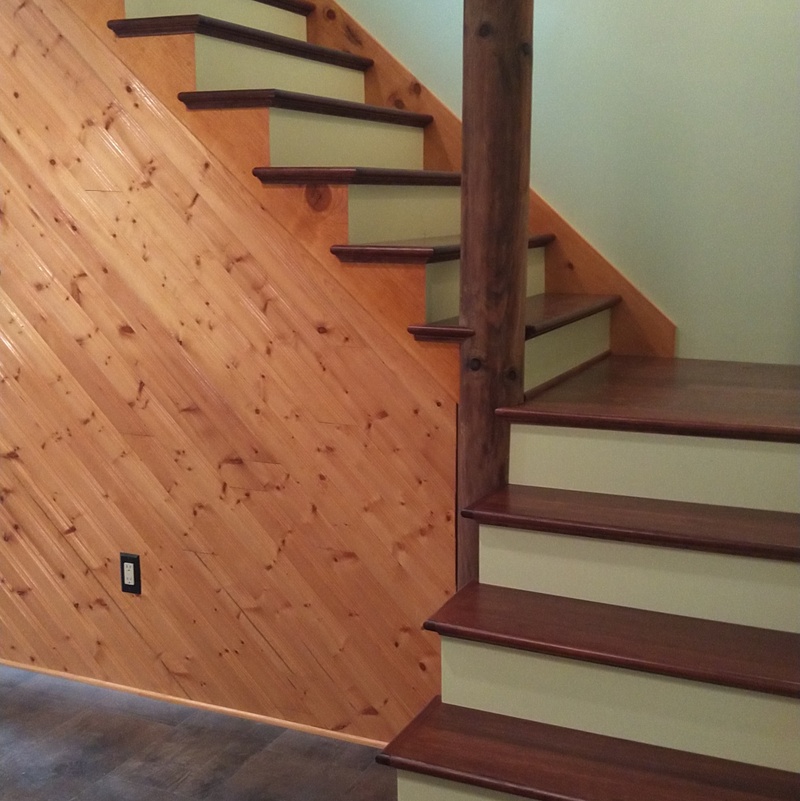 Custom Maple stair treads with mitered risers and Pine skirt boards to match existing aged Pine on walls.
